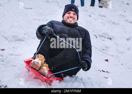 London, Großbritannien. 12.. Dezember 2022. Die Leute im Greenwich Park haben Spaß im Schnee mit den vielen schneebedeckten Hügeln des Royal Park, die viel Platz für Wanderer und diejenigen bieten, die Schlitten fahren, Rodeln und sogar Snowboard fahren wollen. Kredit: Imageplotter/Alamy Live News Stockfoto