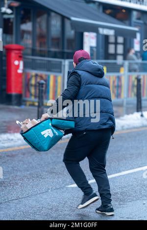 Brentwood, Großbritannien. 12.. Dezember 2022. Brentwood Essex 12.. Dezember 2022 Berichten zufolge schlägt der Brentwood Borough Council vor, Deliveroo-Fahrer von der Abholung in der Brentwood Essex High Street zu „verbieten“. Auf öffentlichen Parkplätzen in der Nähe des Stadtzentrums ist ein Parkplatz für den Fahrer vorzusehen. Es wird ferner berichtet, dass der rat Gespräche mit der Geschäftsleitung von Deliveroo Pictured Deliveroo Fahrern in der Brentwood High Street geführt hat. Kredit: Ian Davidson/Alamy Live News Stockfoto