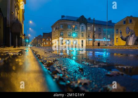 LETTLAND, LIEPAJA - NOVEMBER 5: Liepāja ist eine an der Ostsee gelegene Staatsstadt im Westen Lettlands. Nachtsicht auf eine leere Straße in einer kleinen Stadt auf der N Stockfoto