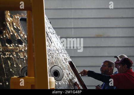 Ein NASA-Ingenieur inspiziert die Orion Capsule auf dem Brunnendeck der USS Portland am Tag nach dem Sturz, nach einer erfolgreichen, nicht besetzten Artemis I Moon Mission am 12. Dezember 2022. Die 26-tägige Artemis-I-Mission brachte das Orion-Raumschiff zum Mond und zurück, um einen historischen Flug zu absolvieren. Poolfoto von Caroline Brehman/UPI Kredit: UPI/Alamy Live News Stockfoto