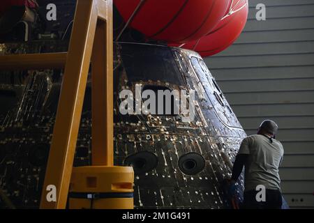 Ein NASA-Ingenieur inspiziert die Orion Capsule auf dem Brunnendeck der USS Portland am Tag nach dem Sturz, nach einer erfolgreichen, nicht besetzten Artemis I Moon Mission am 12. Dezember 2022. Die 26-tägige Artemis-I-Mission brachte das Orion-Raumschiff zum Mond und zurück, um einen historischen Flug zu absolvieren. Poolfoto von Caroline Brehman/UPI Kredit: UPI/Alamy Live News Stockfoto