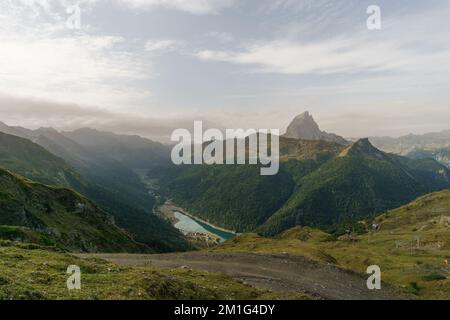 Blick auf ein Tal in den pyrenäen mit dem See Lac de Fabreges und dem felsigen Gipfel d'Ossau im d'Ossau-Tal, Artouste, Nouvelle-Aquitaine, Frankreich Stockfoto