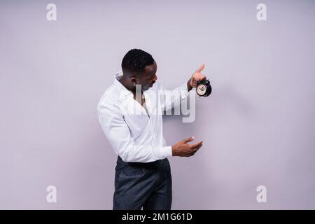 Lächelnder junger afroamerikanischer Mann 20s mit legerem Hemd Brille Mütze Stehfoto Stockfoto