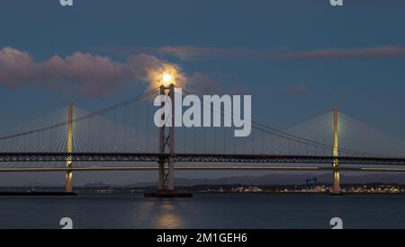 In Blue Hour, Firth of Forth, Schottland, Großbritannien, geht ein Vollmond über die Brücken Queensferry Crossing und Forth Road Stockfoto