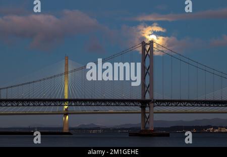 In Blue Hour, Firth of Forth, Schottland, Großbritannien, geht ein Vollmond über die Brücken Queensferry Crossing und Forth Road Stockfoto