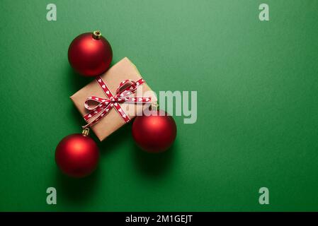 Weihnachtsdekoration und Geschenkbox auf grünem Hintergrund. Stockfoto