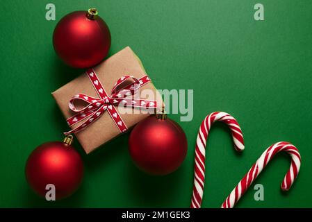 Weihnachtsdekoration und Geschenkbox auf grünem Hintergrund. Stockfoto