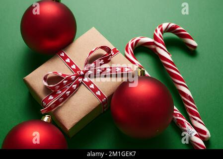 Weihnachtsdekoration und Geschenkbox auf grünem Hintergrund. Stockfoto