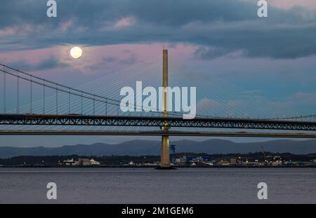 In Blue Hour, Firth of Forth, Schottland, Großbritannien, geht ein Vollmond über die Brücken Queensferry Crossing und Forth Road Stockfoto