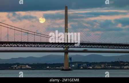 In Blue Hour, Firth of Forth, Schottland, Großbritannien, geht ein Vollmond über die Brücken Queensferry Crossing und Forth Road Stockfoto