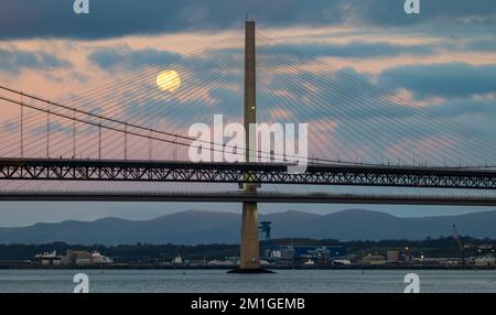 In Blue Hour, Firth of Forth, Schottland, Großbritannien, geht ein Vollmond über die Brücken Queensferry Crossing und Forth Road Stockfoto