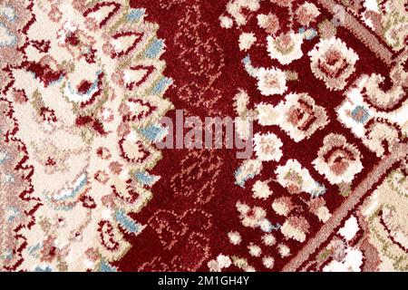Fragment aus persischer Teppichstruktur, Makrofoto für Hintergrund. Nahaufnahme von Details komplexer Muster mit Blumenverzierung des Flurteppichs. Texturkonzept und Hintergrund. Stockfoto