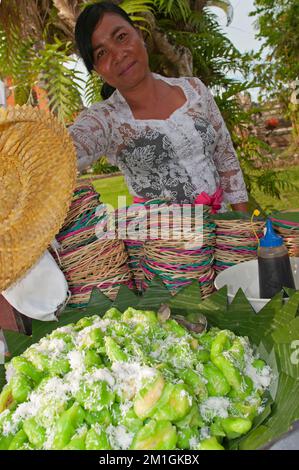 Bali, Indonesien, 29-11-2012-Frau verkauft grüne indonesische Süßigkeiten. Stockfoto