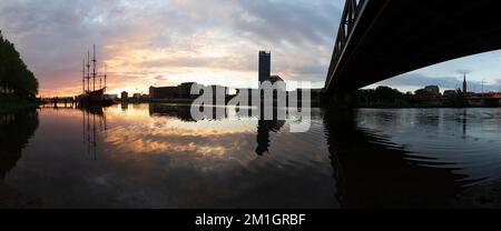 Sonnenuntergang an der Weser in Bremen mit Reflexion der Bürogebäude der Überseestadt Stockfoto