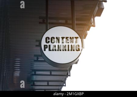 Wirtschaft und Wirtschaft. Unter dem Dach des Gebäudes befindet sich ein kreisförmiges Schild mit der Aufschrift „Content Planning“ (Inhaltsplanung) Stockfoto