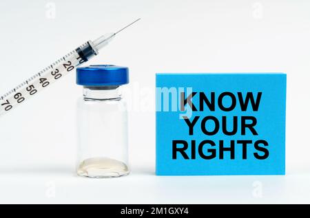 Medizinisches Konzept. Auf dem Tisch befinden sich eine Spritze, eine Injektion und ein blaues Zeichen mit der Aufschrift "Know Your Rights" Stockfoto