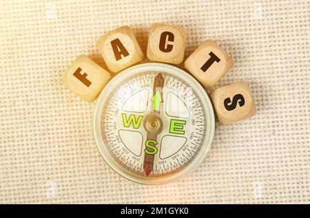 Geschäftskonzept. Auf dem Tisch sind ein Kompass und Würfel mit der Inschrift - FAKTEN Stockfoto