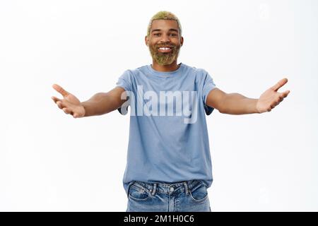 Komm her und umarme dich. Ein netter Kerl, der sich zum Kuscheln die Hände ausstreckt, begrüßt Sie, steht in lässiger Kleidung auf weißem Hintergrund Stockfoto