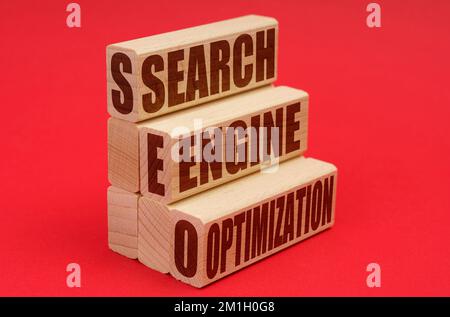 Business- und Economy-Konzept. Auf rotem Hintergrund Holzblöcke mit der Aufschrift „Search Engine Optimization“ Stockfoto