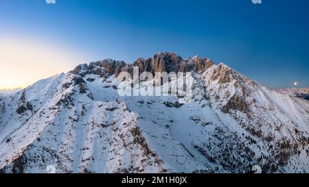 Panoramablick auf den Presolana-Berg im Winter zur Blue Hour. Val Seriana, Castione della Presolana, Bezirk Bergamo, Lombardei, Italien. Stockfoto