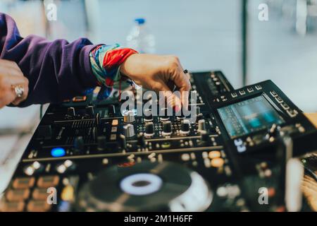 DJ spielt Live-Set und mischt Musik auf der Plattenkonsole auf der Bühne im Nachtclub. Disc Jockey hat einen Soundmixer auf einer Club-Party. DJ-Mixer (Forts. Stockfoto