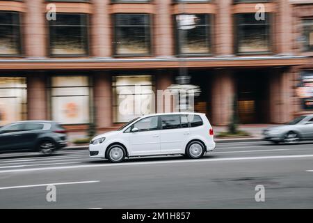 Ukraine, Kiew - 2. August 2021: Weißer Volkswagen Touran fährt auf der Straße. Editorial Stockfoto