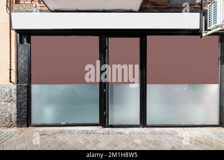 Fassade eines Geschäftsgeländes, von der Kopfsteinpflasterstraße aus gesehen Stockfoto