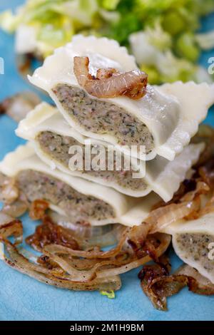 Hälften schwäbische maultaschen Pasta mit Salat Stockfoto