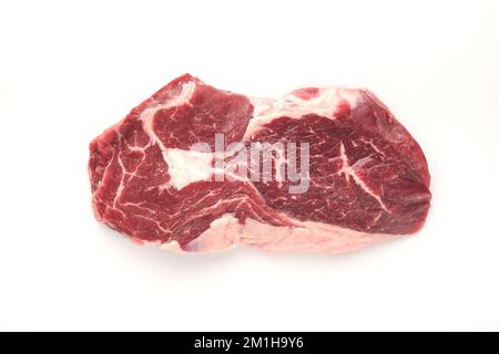 Rohes Steak, isoliert auf Weiß. In Scheiben gegrilltes Fleischsteak New York oder Ribeye mit Gewürzen, Rosmarin und Pfeffer auf weißem Hintergrund. Draufsicht. Modell. Stockfoto