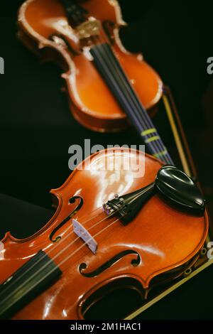 Detailansicht von zwei Violinen auf einigen Stühlen. Stockfoto