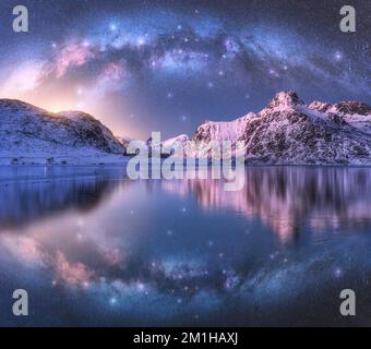 Milchstraße über der Küste und schneebedeckten Bergen Stockfoto