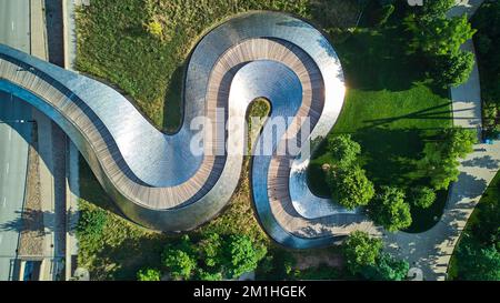 Der wellige Schlangenmetallpfad der Fußgängerbrücke von oben im Millennium Park in Chicago Stockfoto
