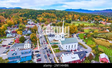 Wunderschöner Blick aus der Vogelperspektive auf die kleine Stadt Stowe in Vermont, die sich im Herbstlaub befindet und sich auf die Kirche konzentriert Stockfoto