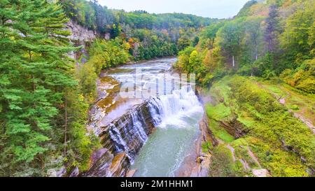 Magischer Wasserfall versteckt in Wäldern, erodierende Klippen mit Herbstlaub Stockfoto