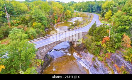 Die Stone Bridge Road überquert die Brücke im New Yorker Herbstwald Stockfoto