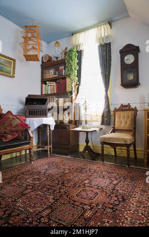 Eastlake gepolsterter Stuhl und antike Möbel im Zimmer im Obergeschoss in einem alten Haus im viktorianischen Landhausstil aus dem Jahr 1904. Stockfoto