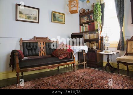 Eastlake Sofa und Polstersessel mit antiken Möbeln im Zimmer im Obergeschoss in einem alten Haus im viktorianischen Landhausstil aus dem Jahr 1904. Stockfoto