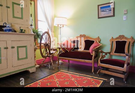 Ca. 1850 Kiefernholzbuffet und Eastlake Love Seat und Sessel im oberen Zimmer im alten viktorianischen Haus im Stil von 1904. Stockfoto