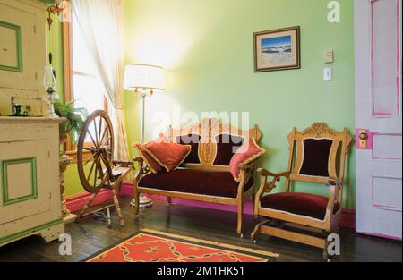 Ca. 1850 Kiefernholzbuffet und Eastlake Love Seat und Sessel im oberen Zimmer im alten viktorianischen Haus im Stil von 1904. Stockfoto