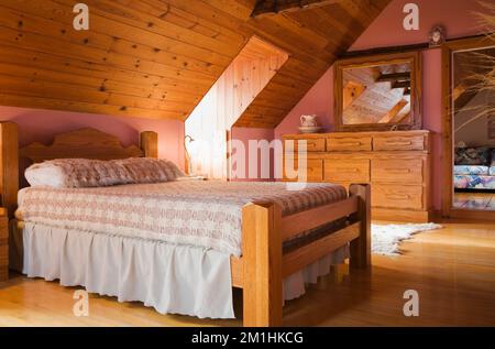 Holzrahmen Doppelbett im Hauptschlafzimmer im 1982 erbauten Nachbau des alten 1800er Blockhauses, Quebec, Kanada. Dieses Bild ist Eigentum, das für calenda freigegeben wurde Stockfoto