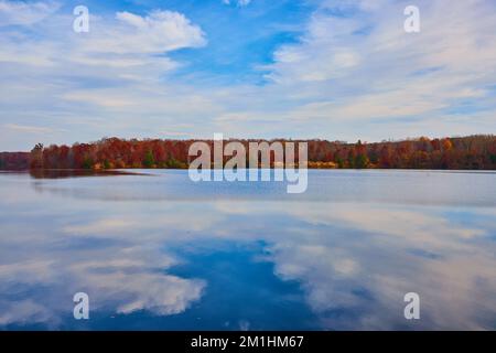 Kristallklare Seenoberfläche mit Herbstwäldern entlang der Küste von Michigan Stockfoto