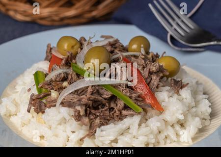 Nahaufnahme von zerkleinertem Fleisch mit Reis und Oliven, typisch kubanisches Essen. Stockfoto