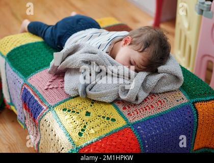 Süßes Kleinkind, das auf einem Futon schläft Stockfoto