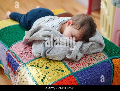 Süßes Kleinkind, das auf einem Futon schläft Stockfoto
