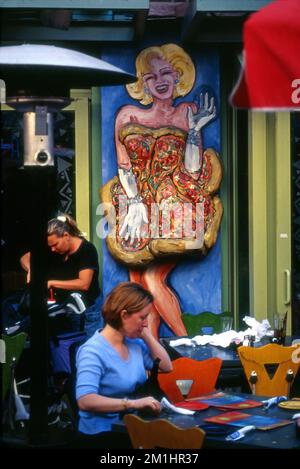 Restauranttisch unter einem Gemälde einer Marilyn Monroe ähnlichen Schauspielerin im Citywalk der Universal Studios Tour in Los Angeles, CA Stockfoto