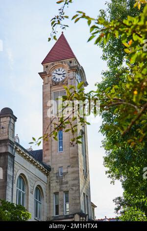 Beeindruckender Uhrenturm aus Kalkstein auf dem Campus des Colleges in Bloomington Stockfoto