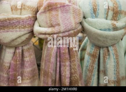 Warme Schals auf weißem Hintergrund. Stilvolles Set mit Herbst-Winter-Accessoires, bequemem Wollschal. Winterkonzept von Komfort und Entspannung. Stockfoto