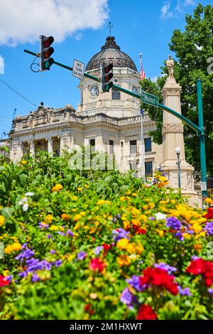 Das Gerichtsgebäude von Bloomington Indiana mit verschwommenen bunten Sommerblumen im Vordergrund Stockfoto