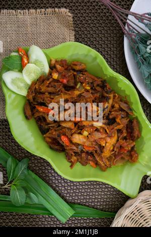 Pampis Tongkol/Cakalang, Manados traditionelles Fischgericht mit scharfem Fisch, serviert auf grünem Teller Stockfoto