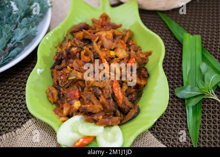 Pampis Tongkol/Cakalang, Manados traditionelles Fischgericht mit scharfem Fisch, serviert auf grünem Teller Stockfoto